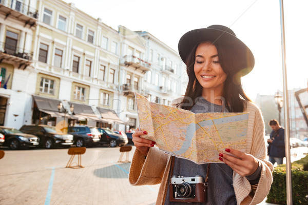 Portrait of a smiling attractive woman tourist holding city map Stock photo © deandrobot
