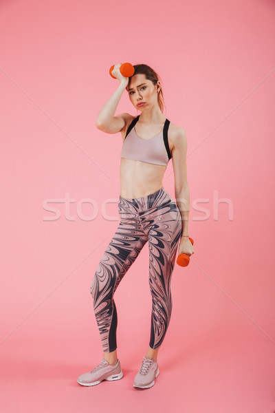 Full length image of tired sportswoman relaxing with dumbbells Stock photo © deandrobot