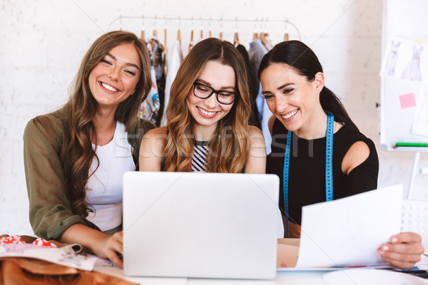 Three happy young women clothes designers Stock photo © deandrobot