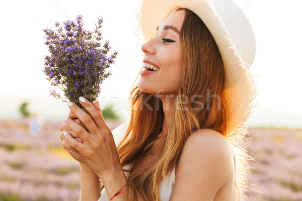 Beautiful young girl in straw hat holding lavender bouquet Stock photo © deandrobot