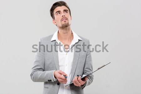 Portrait of a pensive asian man with arms folded isolated on a white background Stock photo © deandrobot