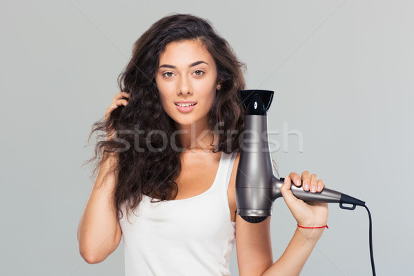 Happy beautiful woman holding hairdryer Stock photo © deandrobot