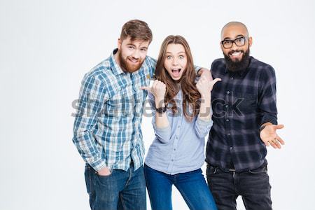 Happy three friends in casual wear standing and laughing  Stock photo © deandrobot