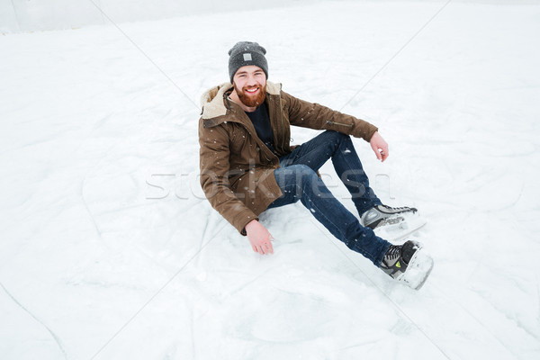Man sitting on the snow in ice skates  Stock photo © deandrobot