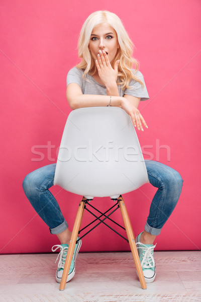 Erstaunt blonde Frau Sitzung Stuhl rosa Mädchen Stock foto © deandrobot