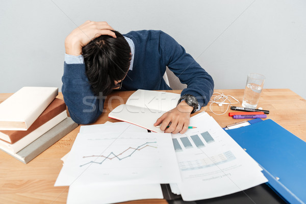 Asian man sleeps on the table with notebooks Stock photo © deandrobot