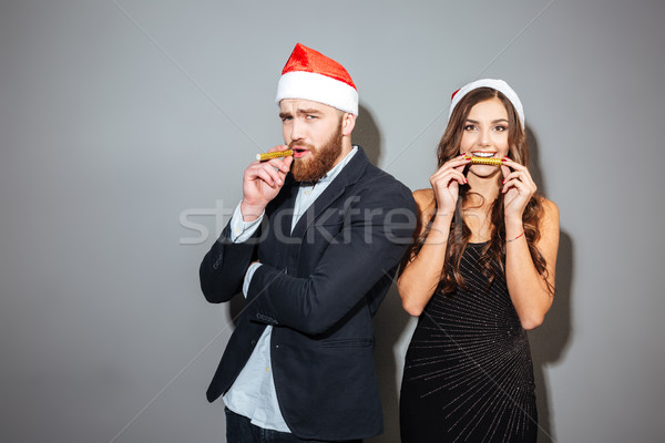 Happy couple in formal clothes and santa hat celebrating christmas Stock photo © deandrobot