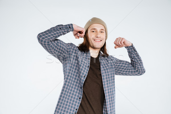 Smiling Hipster showing his biceps Stock photo © deandrobot