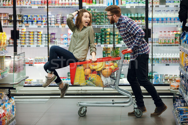 Beautiful couple having fun while choosing food in the supermarket Stock photo © deandrobot