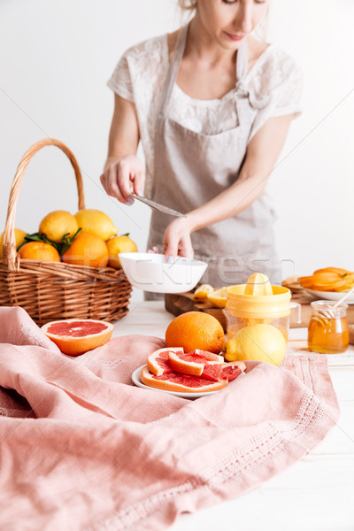 Cropped image of woman squeezes out juice of a citruses. Stock photo © deandrobot