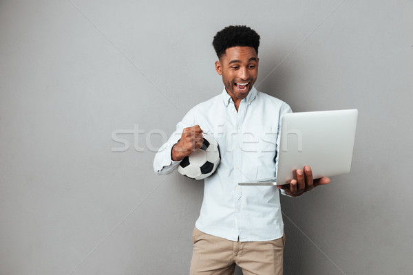 Heyecanlı afro amerikan adam bakıyor dizüstü bilgisayar Stok fotoğraf © deandrobot