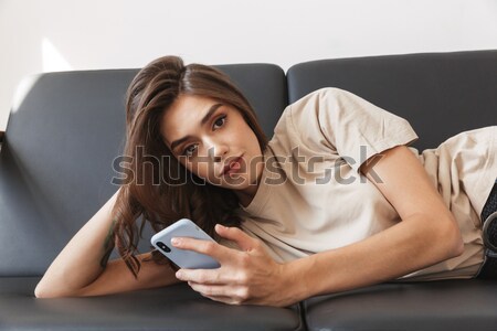 Attractive asian woman in sexy lingerie using mobile phone Stock photo © deandrobot