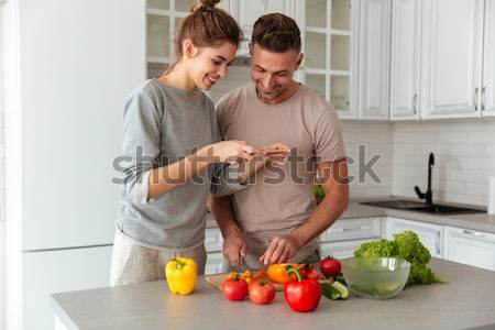 Stock photo: Portrait of a laughing loving couple cooking salad together