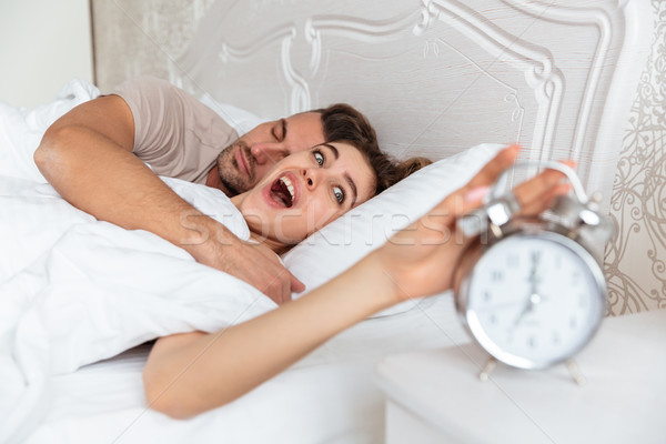 Side view of Surprised Lovely couple sleeping together in bed Stock photo © deandrobot