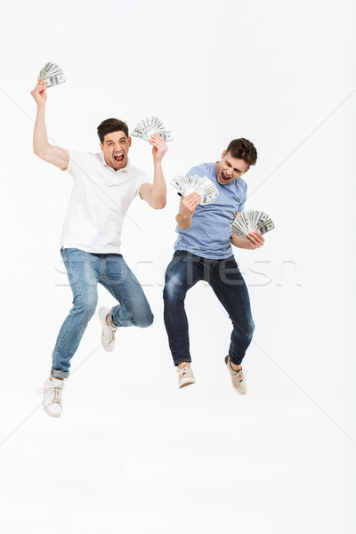 Full length portrait of two happy young men Stock photo © deandrobot