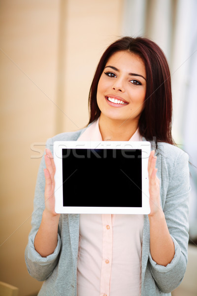 Young beautiful businesswoman showing ipad where you can put your image or text Stock photo © deandrobot