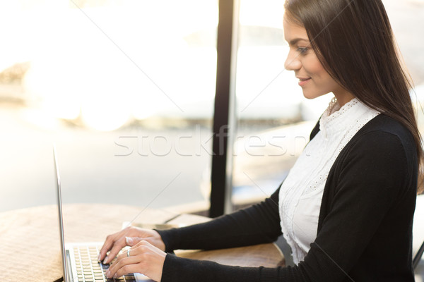 Smiling businesswoman using laptop in cafe Stock photo © deandrobot