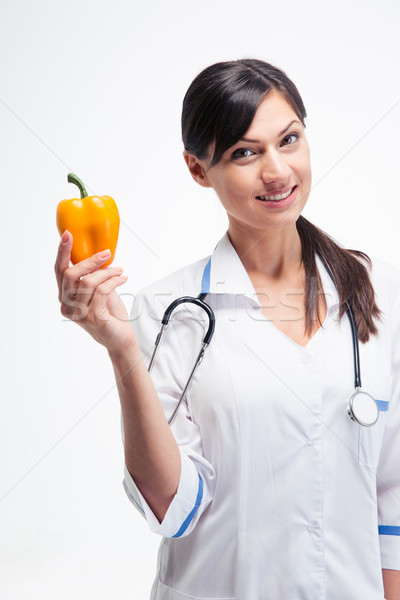 Stock photo: Smiling female doctor holding peppe