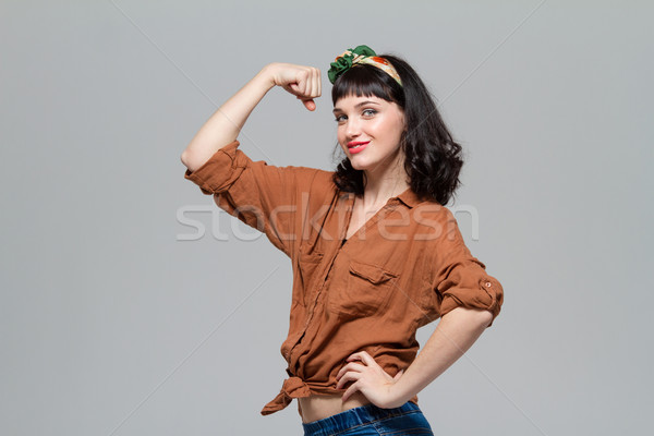 Gyönyörű pozitív boldog fiatal nő mutat bicepsz Stock fotó © deandrobot