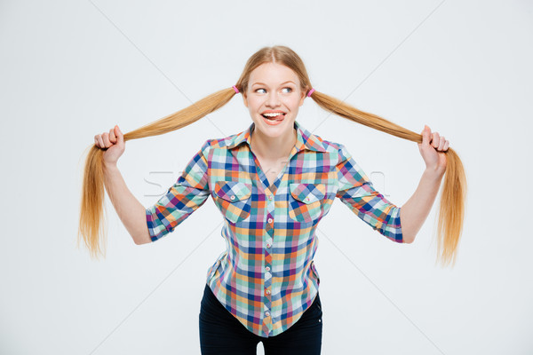 Funny young woman holding her ponytail Stock photo © deandrobot