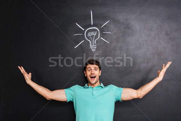 Smiling excited young man standing and having an idea Stock photo © deandrobot