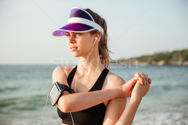 Fitness runner doing warm-up routine on beach before running Stock photo © deandrobot