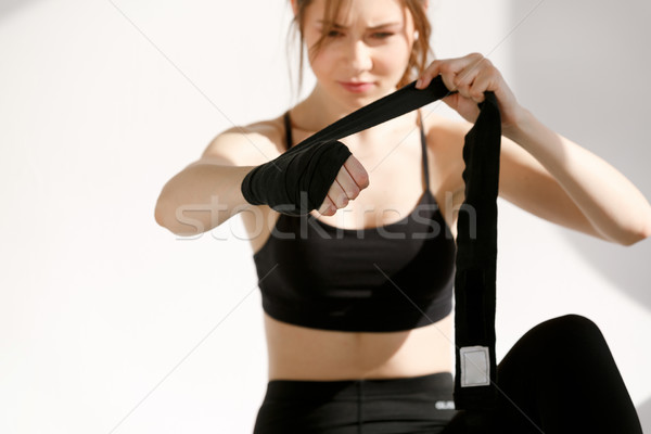 Sports woman wraping her hands with bandage before work out Stock photo © deandrobot