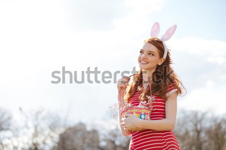 Portrait of red head woman wearing bunny ears Stock photo © deandrobot