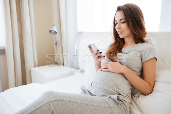 Foto stock: Sorridente · mulher · grávida · sessão · cama · casa