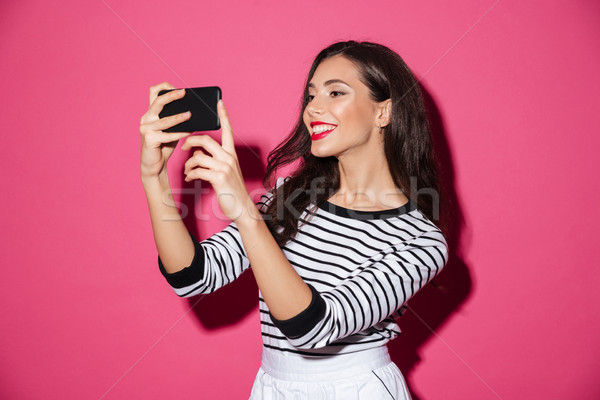 Portrait of a smiling girl taking a selfie Stock photo © deandrobot