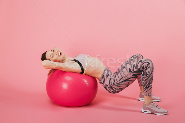 Side view of Happy sportswoman doing exercise with fitness ball Stock photo © deandrobot