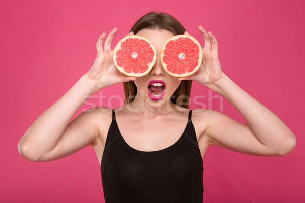 Joyful female with two half of grapefruit instead eyes Stock photo © deandrobot