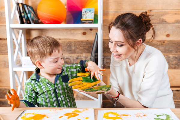 Joyful mother and her little son painting on their hands Stock photo © deandrobot