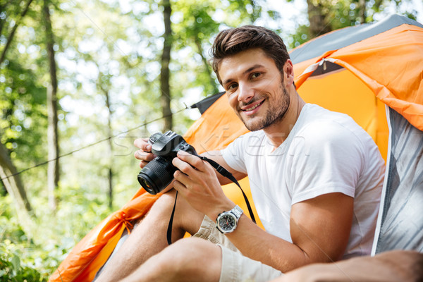 Man tourist sitting and using photo camera in touristic tent Stock photo © deandrobot