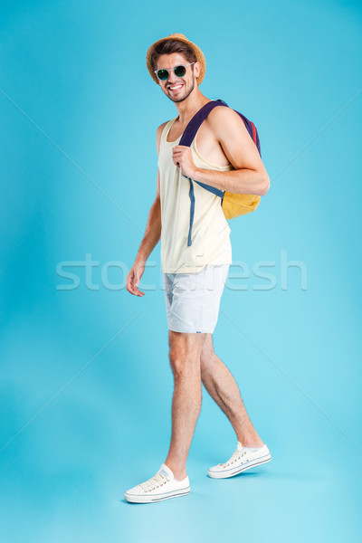 Happy handsome young man with backpack walking and smiling Stock photo © deandrobot