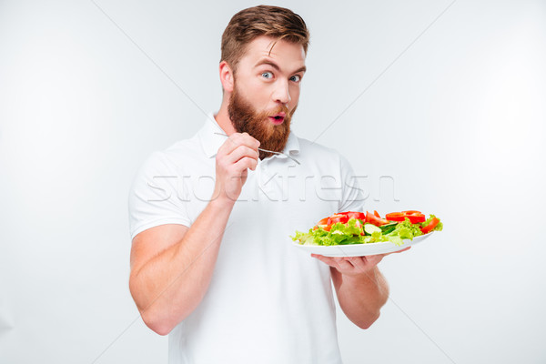 Happy excited bearded man holding plate with fresh sala a, Stock photo © deandrobot