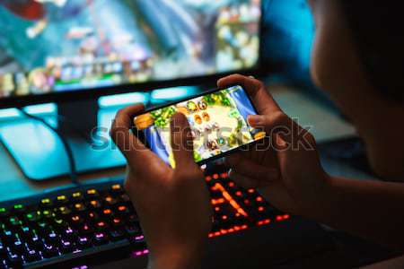 Primo piano uomo giocare videogioco smartphone sera Foto d'archivio © deandrobot