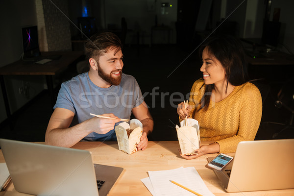 Business colleagues working at night while eating. Stock photo © deandrobot