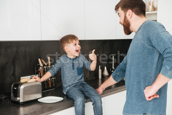 Young father cooking at kitchen with his little cute son Stock photo © deandrobot