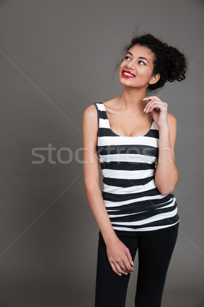 Smiling lovely afro american girl standing and looking away Stock photo © deandrobot