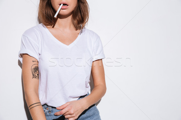 Foto mujer atractiva cigarrillo blanco camiseta pie Foto stock © deandrobot