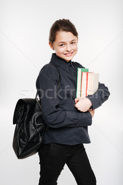 Smiling young girl holding books Stock photo © deandrobot