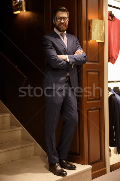 Boldog fiatal szakállas üzletember áll létra Stock fotó © deandrobot