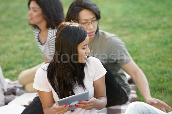 Smiling students studying outdoors. Looking aside. Stock photo © deandrobot