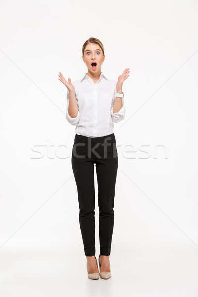 Full length image of shocked blonde business woman holding hands Stock photo © deandrobot