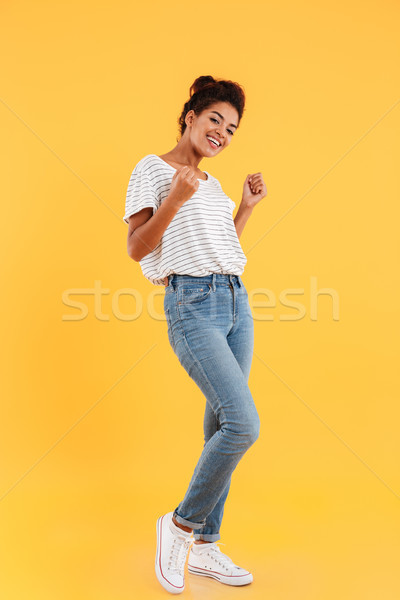 Full-length shot of pretty african lady smiling to camera isolated Stock photo © deandrobot