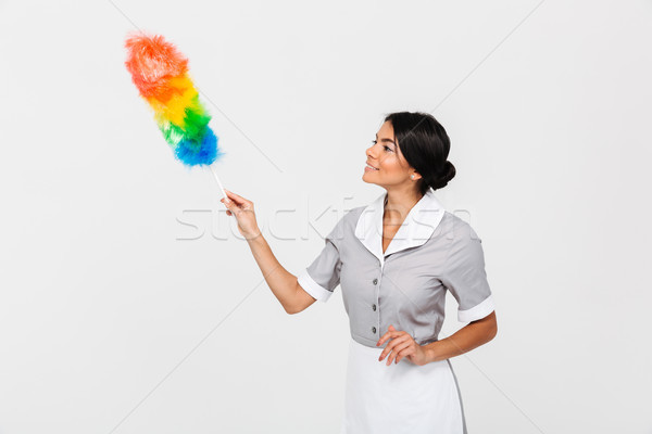 Close-up photo of young cheerful housekeeper in uniform cleaning Stock photo © deandrobot