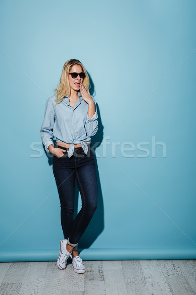 Full length image of Happy woman in shirt and sunglasses Stock photo © deandrobot