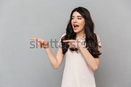 Image of sassy woman with long brown hair emotionally putting fi Stock photo © deandrobot