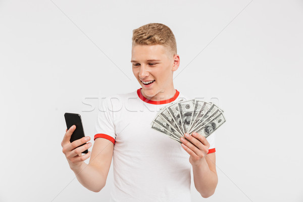 Portrait of a happy teenage boy holding money banknotes Stock photo © deandrobot